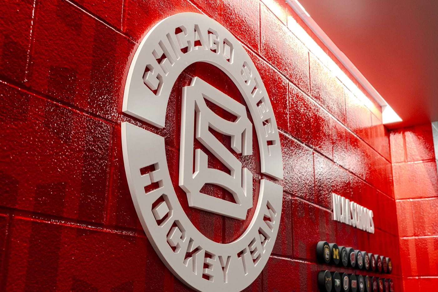 Dimensional Chicago Steel logo on a red brick wall
